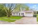 Charming home with a well-manicured front yard, mature trees, and a driveway leading to the garage at 1213 Fairview Dr, Greenfield, IN 46140