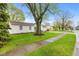 Well-kept ranch home with green lawn, landscaping, and a mature tree providing ample shade at 1213 Fairview Dr, Greenfield, IN 46140