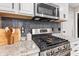 Up close shot of stainless gas range and microwave with gray subway tile backsplash at 1213 Fairview Dr, Greenfield, IN 46140