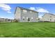 Spacious, grassy backyard with a partial view of the neighborhood at 12902 Girvan Way, Fishers, IN 46037