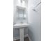 Powder room featuring a pedestal sink, decorative mirror, and sleek hardware at 12902 Girvan Way, Fishers, IN 46037