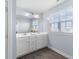 Bright bathroom with double sink vanity, large mirror, wood look floors, and a large window with natural light at 12902 Girvan Way, Fishers, IN 46037