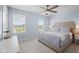 Bright bedroom with a ceiling fan, two windows, and a bed with a tufted headboard at 12902 Girvan Way, Fishers, IN 46037