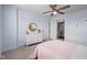 Light-filled bedroom featuring a white dresser with gold accents, a ceiling fan, and access to laundry at 12902 Girvan Way, Fishers, IN 46037