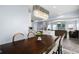 Open concept dining room with a modern chandelier, wood table and chairs, and views to the living room at 12902 Girvan Way, Fishers, IN 46037