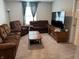 Cozy living room with soft brown couches, a wooden coffee table, and natural lighting at 1303 Eton Way, Avon, IN 46123