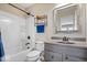 Neutral bathroom with a shower-tub, vanity, and decorative mirror at 1352 Trifecta Way, Westfield, IN 46074