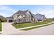 Spacious two-story home with a three-car garage, stone accents, and meticulously maintained front yard at 1352 Trifecta Way, Westfield, IN 46074