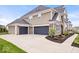 Exterior showcasing a three-car garage with stone accents and meticulously maintained landscaping at 1352 Trifecta Way, Westfield, IN 46074