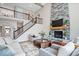 Cozy living room featuring a stone fireplace, high ceilings, and modern staircase with iron railings at 1352 Trifecta Way, Westfield, IN 46074