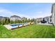 Lush backyard with a pristine pool, stamped concrete patio, outdoor fireplace, and manicured landscaping at 1352 Trifecta Way, Westfield, IN 46074