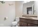 Charming powder room with a vanity, mirror, and toilet featuring beach-themed decor at 1352 Trifecta Way, Westfield, IN 46074