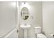 Bathroom featuring a pedestal sink, oval mirror, tile floors, and a view into the living room at 13567 Moorcroft Dr, Fishers, IN 46037