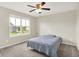 Bright bedroom with a ceiling fan, plush carpet, and a view from a large window at 13567 Moorcroft Dr, Fishers, IN 46037