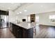 Open kitchen features stainless steel appliances, dark cabinets and a view into the living room fireplace at 13567 Moorcroft Dr, Fishers, IN 46037