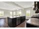 Bright kitchen features dark cabinetry, stainless appliances, large island and hardwood floors at 13567 Moorcroft Dr, Fishers, IN 46037