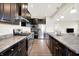 Stylish kitchen featuring dark cabinets, granite counters, stainless appliances and hardwood flooring at 13567 Moorcroft Dr, Fishers, IN 46037