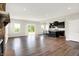 Open-concept living room with hardwood floors, a view of the kitchen, and sliding door access to outdoors at 13567 Moorcroft Dr, Fishers, IN 46037