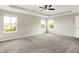 Large main bedroom features plush carpet, a ceiling fan, and bright windows overlooking the landscape at 13567 Moorcroft Dr, Fishers, IN 46037