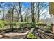 Beautifully landscaped backyard with manicured hedges, brick path, and mature trees create a serene outdoor space at 13587 Kensington Pl, Carmel, IN 46032