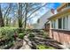 Well-maintained backyard features a brick pathway, manicured hedges, and leads to the home's exterior at 13587 Kensington Pl, Carmel, IN 46032