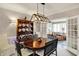 Elegant dining room featuring a modern chandelier, a wooden table, and a large hutch for storage at 13587 Kensington Pl, Carmel, IN 46032