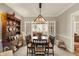 Well-lit dining room featuring a wooden table, stylish lighting, and a hutch with decorative items at 13587 Kensington Pl, Carmel, IN 46032