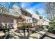 Exterior view of a brick home with a back deck, landscaping, and mature trees at 13587 Kensington Pl, Carmel, IN 46032