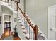 Inviting foyer with hardwood floors, a staircase, and view to the kitchen at 13587 Kensington Pl, Carmel, IN 46032