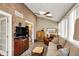 Bright living room with exposed brick, skylights, a ceiling fan, and neutral decor at 13587 Kensington Pl, Carmel, IN 46032