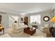 Comfortable living room with bay window, plush seating, and staircase view, perfect for relaxing at 13587 Kensington Pl, Carmel, IN 46032