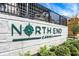 'Northend Carmel' community sign surrounded by green landscaping and nearby building, showcasing the area's development at 13587 Kensington Pl, Carmel, IN 46032