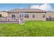 Well-maintained backyard with a wooden deck, lush green lawn, and vinyl siding on the home at 1361 Trescott Dr, Westfield, IN 46074