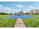 Outdoor blue basketball court with benches, surrounded by lush green grass and a clear blue sky at 1361 Trescott Dr, Westfield, IN 46074