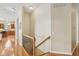 Hallway with hardwood floors and wood banister leads to the home's lower level at 1361 Trescott Dr, Westfield, IN 46074