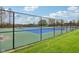 Exterior view of a fenced-in tennis court with a green and blue playing surface and well-maintained grass at 1361 Trescott Dr, Westfield, IN 46074