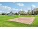 Sand volleyball court with net, surrounded by manicured green grass, with basketball court and sky in background at 1361 Trescott Dr, Westfield, IN 46074