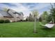 Expansive backyard with lush green lawn, mature trees, and a relaxing hammock at 13948 Silver Stream Dr, Carmel, IN 46032