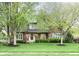 Charming two-story home boasts a manicured lawn and mature trees at 13948 Silver Stream Dr, Carmel, IN 46032