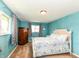 Bright bedroom with blue textured walls, two windows, and a wooden armoire at 143 Beechview Ln, Indianapolis, IN 46217