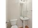 Small bathroom featuring a pedestal sink, a toilet, light colored walls and wood trim at 14323 Chariots Whisper Dr, Carmel, IN 46074