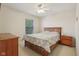 Comfortable bedroom featuring a wood-framed bed, a ceiling fan and a window with natural light at 14323 Chariots Whisper Dr, Carmel, IN 46074