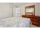 Cozy bedroom featuring a bed with patterned bedding and a dark wooden dresser with mirror at 14323 Chariots Whisper Dr, Carmel, IN 46074