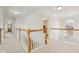 Hallway featuring a wooden banister, neutral walls and carpet, and access to rooms for easy navigation at 14323 Chariots Whisper Dr, Carmel, IN 46074