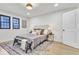 Bedroom featuring light hardwood floors, a window with black trim, and a large area rug under the bed at 15 N Campbell Ave, Indianapolis, IN 46219