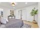 Bright bedroom featuring light hardwood floors, recessed lights, and large sliding double doors to closet or ensuite at 15 N Campbell Ave, Indianapolis, IN 46219
