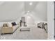 Bonus room features neutral carpeting, vaulted ceilings, seating, and bright white walls at 15 N Campbell Ave, Indianapolis, IN 46219