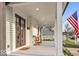 Inviting front porch features seating, dark wood doors, and a charming exterior at 15 N Campbell Ave, Indianapolis, IN 46219