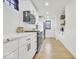 Modern kitchen featuring white cabinets, wooden shelving, and tiled backsplash at 15 N Campbell Ave, Indianapolis, IN 46219