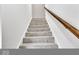 Staircase with neutral carpeting, white walls, and a wooden handrail creates an inviting transition between floors at 15 N Campbell Ave, Indianapolis, IN 46219